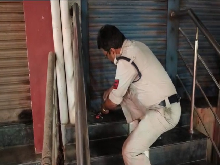 बबीना बार के पीछे के शटर को सील करता आबकारी विभाग का सिपाही - Dainik Bhaskar