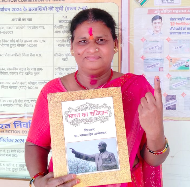 भोपाल के पुलिस पब्लिक स्कूल नेहरू नगर में गीता देवी सरवैया ने संविधान हाथ में लेकर किया मतदान।