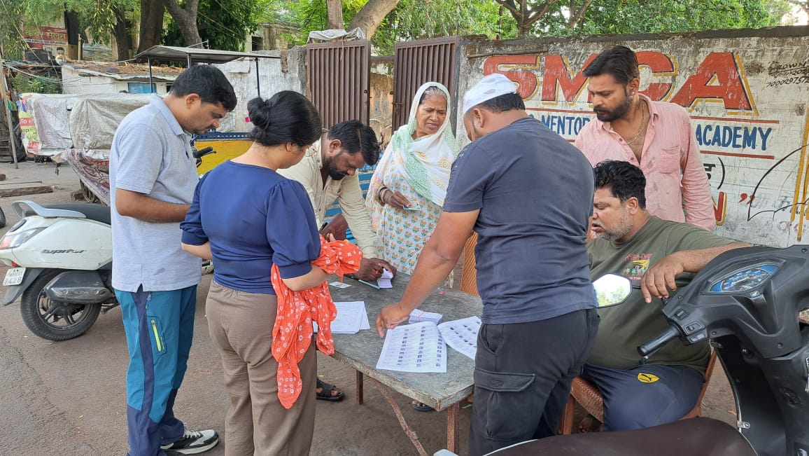 भोपाल के 6 नंबर स्थित अंकुर स्कूल के मतदान केंद्र के बाहर वोटर लिस्ट में अपना नाम देखते मतदाता।