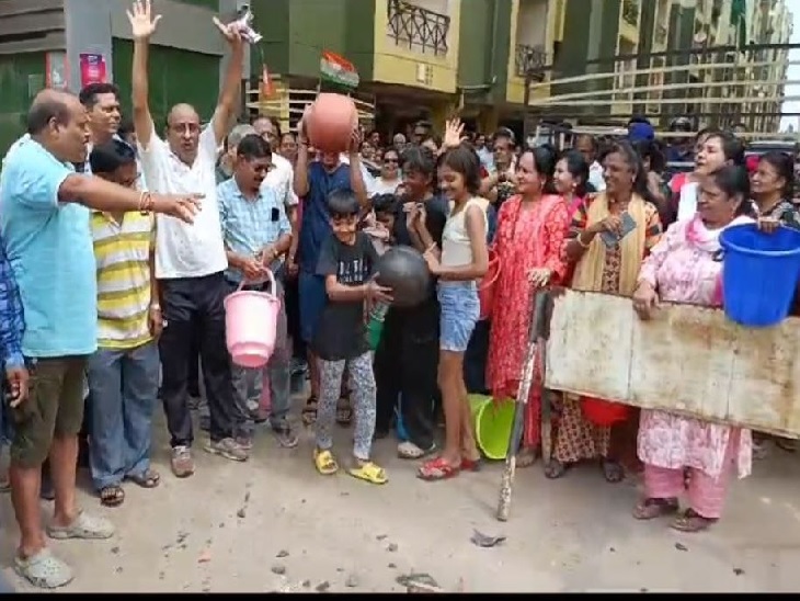 कालोनी के सामने मटका फोड़कर घेराव करते कालोनी के लोग - Dainik Bhaskar