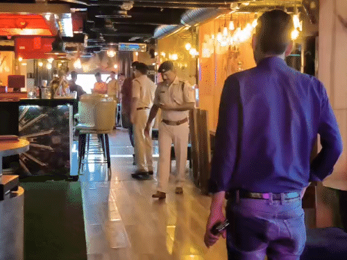 फायरिंग के बाद बार में पहुंची पुलिस।