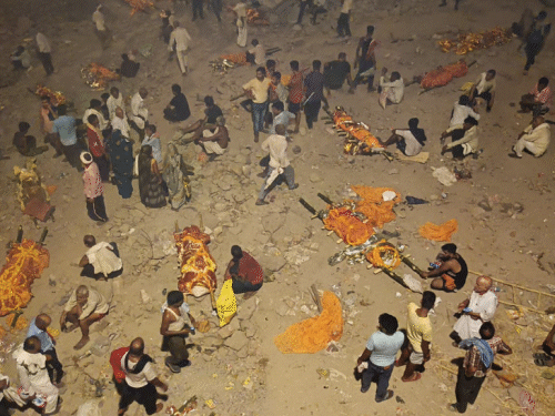 यह फोटो मणिकर्णिका घाट की है। घाट और उसके आसपास रखी हुई लाशों के साथ परिजन।