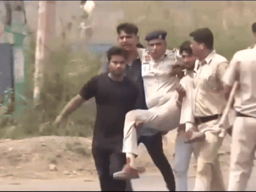 घायल पुलिस कर्मचारी को लेकर जाते लोग।