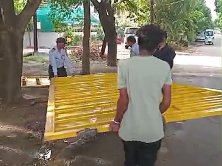 गेट को काटकर किनारे रखते हुए निगम के कर्मचारी।