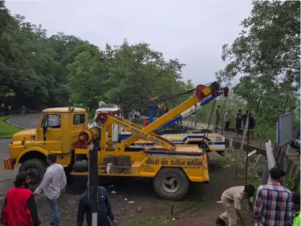 जेसीबी और क्रेन की मदद से बस को खाई से बाहर निकाला जा रहा है।