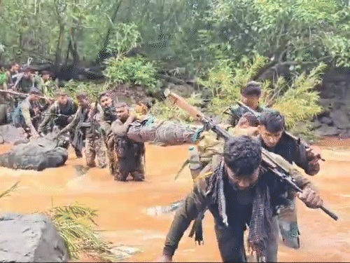 महिला नक्सली की लाश लेकर उफनती नदी को पार करते जवान।