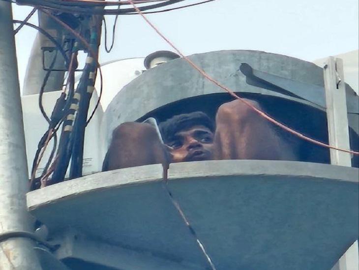 टावर के ऊपर बैठकर मोबाइल से बात करता युवक। - Dainik Bhaskar