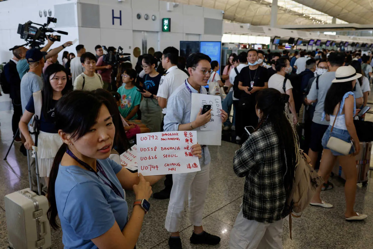 Employees at Hong Kong airport were seen writing flight details on paper and informing passengers.
