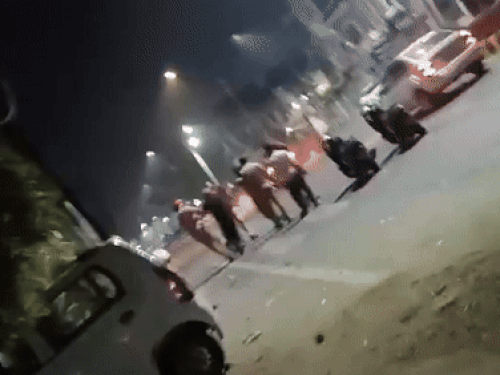 धर्मपुरा पुलिस चौकी के बाहर पिता-पुत्र को चौकी में ले जाती पुलिस।