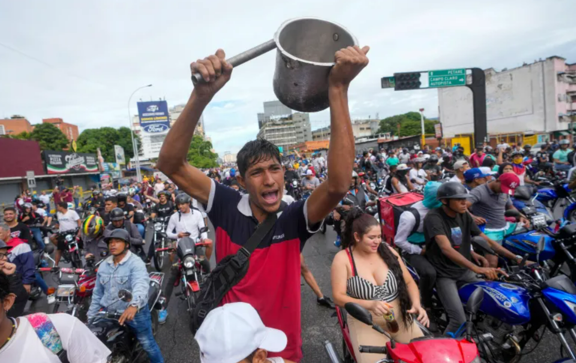 People are protesting by banging utensils on the streets.