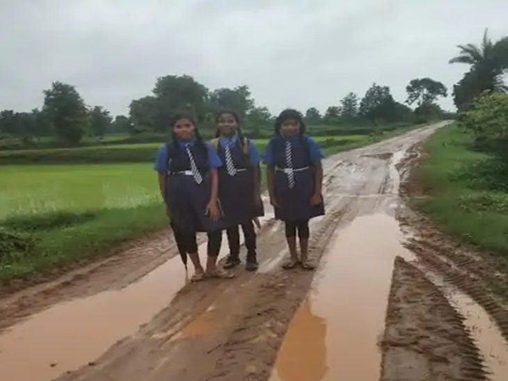 कीचड़ से सनी खराब सड़क पर चलने से स्कूली बच्चों के कपड़े खराब हो जाते हैं।