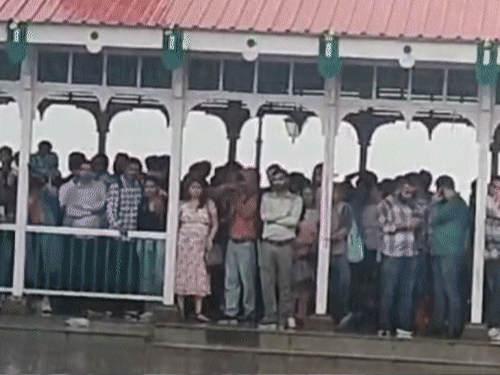 शिमला में बारिश के बीच रिज पर रेन शेल्टर में रुके लोग