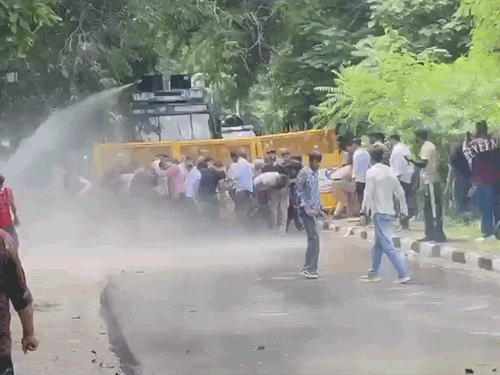 युवाओं पर पानी की बौछार करती पुलिस।