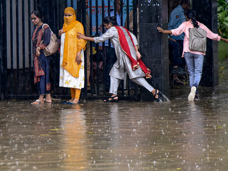 Girls saving themselves from rain water in Patna, Bihar.