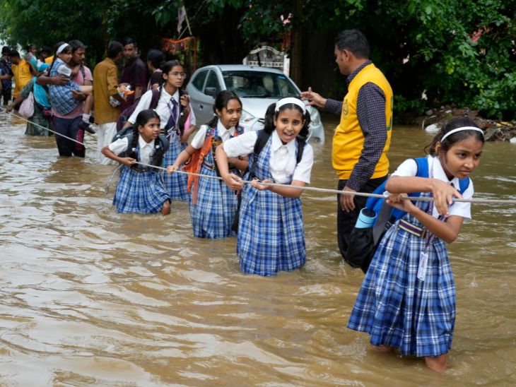 Roads were flooded after heavy rains in Ajmer, Rajasthan. School children were helped to cross the road with the help of a rope.