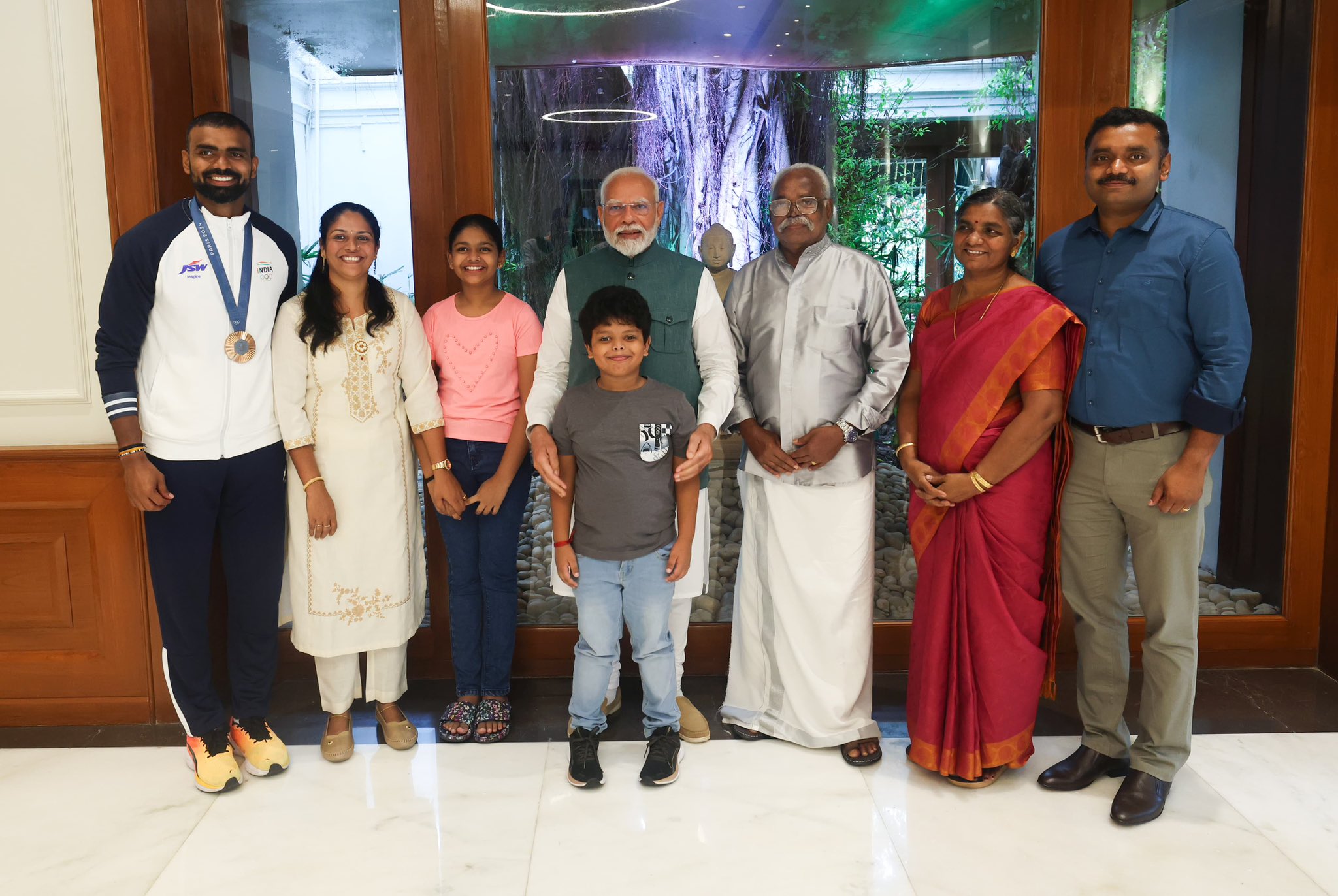 पीआर श्रीजेश के परिवार के साथ पीएम मोदी। श्रीजेश ने ये फोटो 15 अगस्त को एक्स पर पोस्ट की थी.