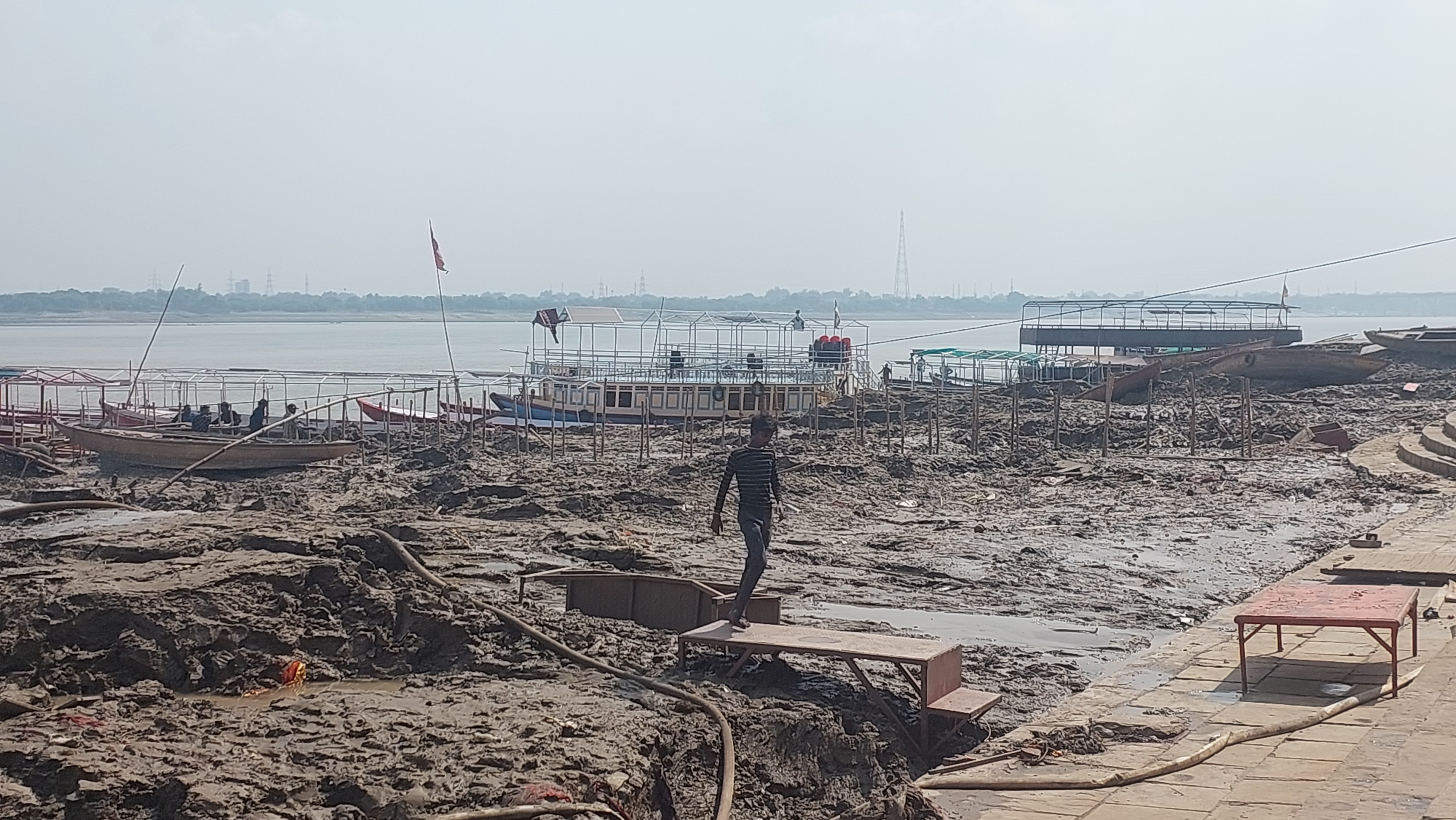 टीन और पटरा लगाकर नाव तक पर्यटकों को लेकर जा रहे नाविक।