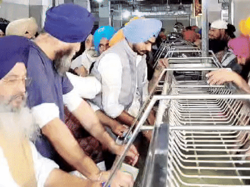 भांडी साफ करण्याची सेवा करताना अकाली पार्टी बिक्रम मजिठिया.