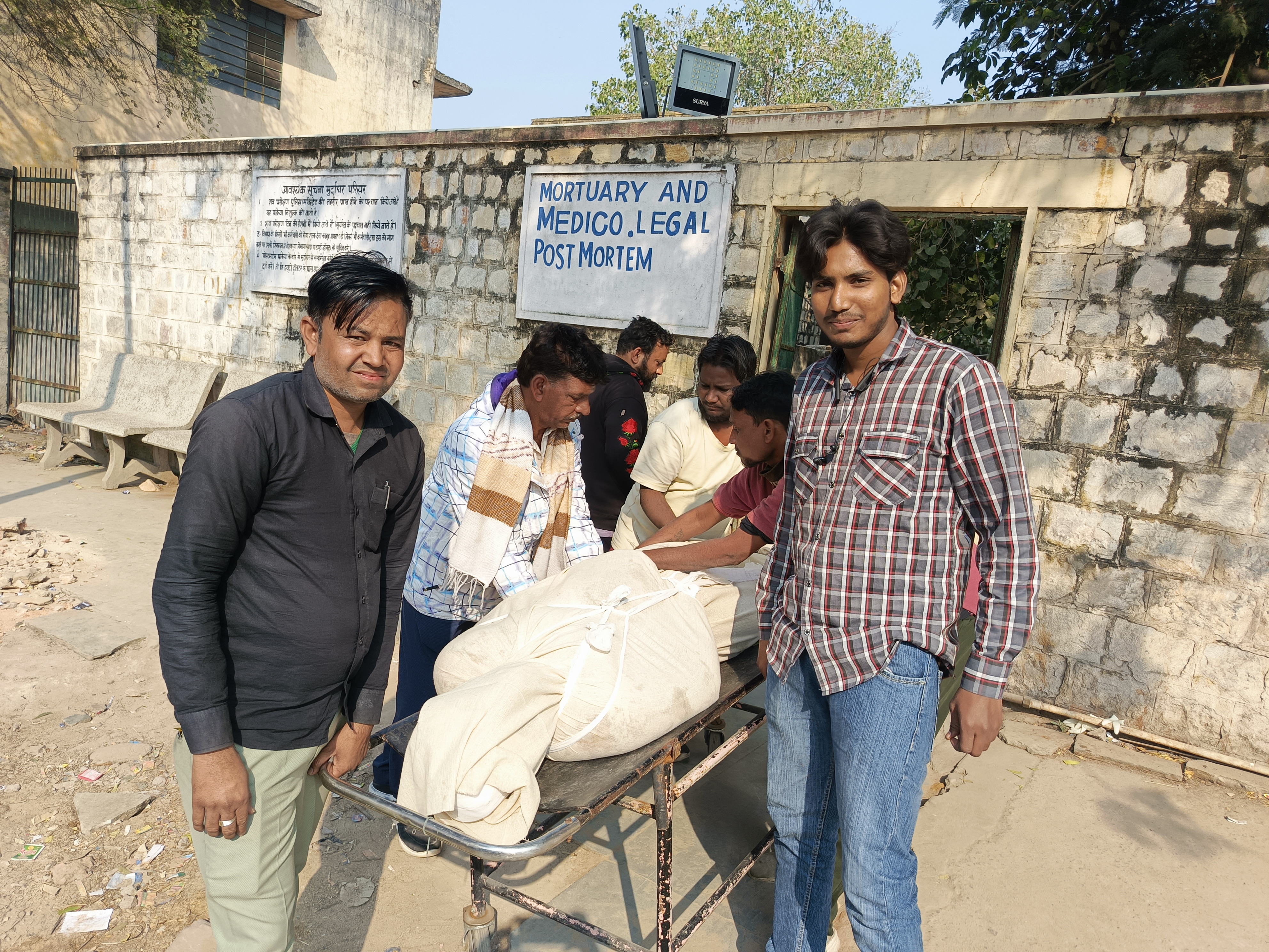 फेजान का शव मोर्चरी से बाहल लाते हुए वार्ड बॉय और उनके मामा।