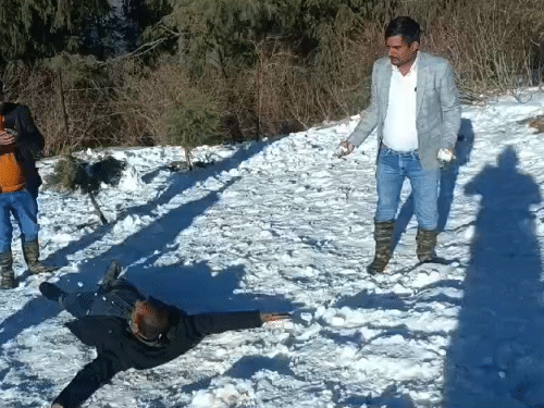 Tourists having fun lying on the snow at Mahasu Peak, about 18 kilometers from Shimla.