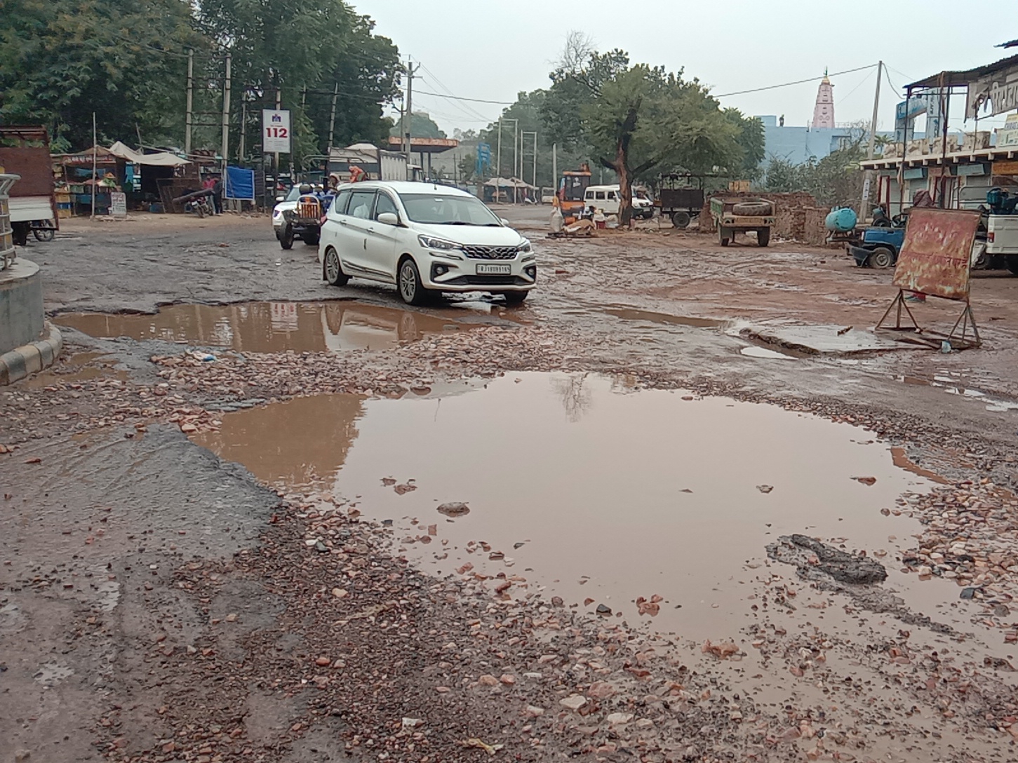देवीलाल चौक पर बने गड्ढों के बीच से गुजरते वाहन।