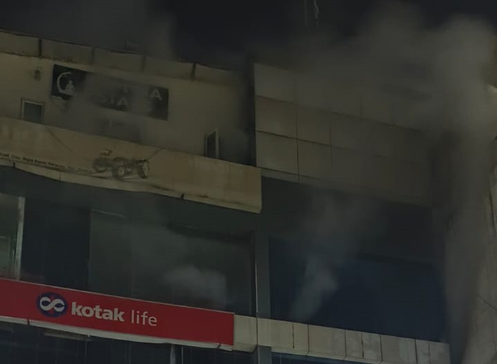 सिगरा स्थित महिंद्रा कोटेक शोरूम से निकलता धुंआ। इसके शीशे तोड़कर अंदर का धुआं बाहर निकाला जा सका।