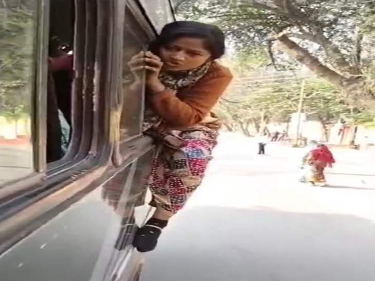 पुलिस की गाड़ी में एक महिला शिक्षक खिड़की से बाहर लटकती दिखाई दी।