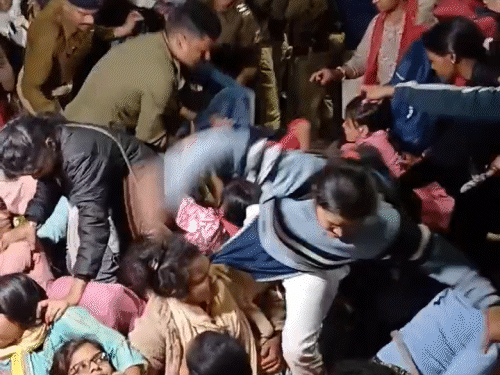 प्रदर्शन कर रही महिला शिक्षकों के बीच में घुसकर टीचर के पैर खींचता हुआ पुलिसकर्मी।
