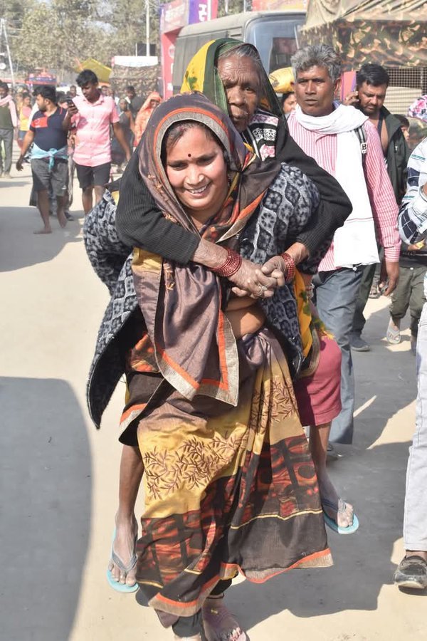भीड़ में एक महिला अपनी सास को पीठ पर लादकर ले जाते दिखी।