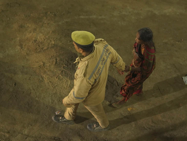 ਪੁਲਿਸ ਕਰਮਚਾਰੀ ਬੁੱ old ੀ woman ਰਤ ਦਾ ਹੱਥ ਫੜਨ ਜਾ ਰਹੇ ਹਨ ਅਤੇ ਉਸਨੂੰ ਹੋਂਦ ਵਿੱਚ ਲੈ ਜਾ ਰਹੇ ਹਨ.