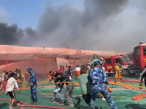 Fire Brigade team and RAF personnel trying to extinguish the fire.