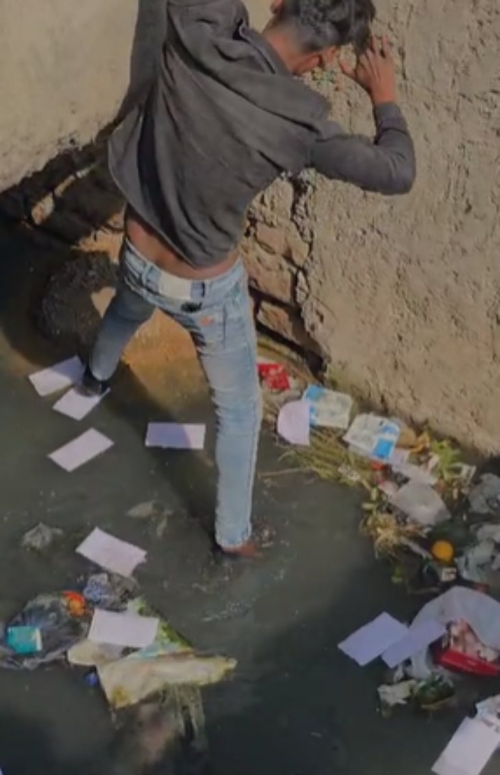 स्थानीय लोगों के कहने पर एक युवक ने नाले से पैसों से भरे लिफाफे को निकाला।