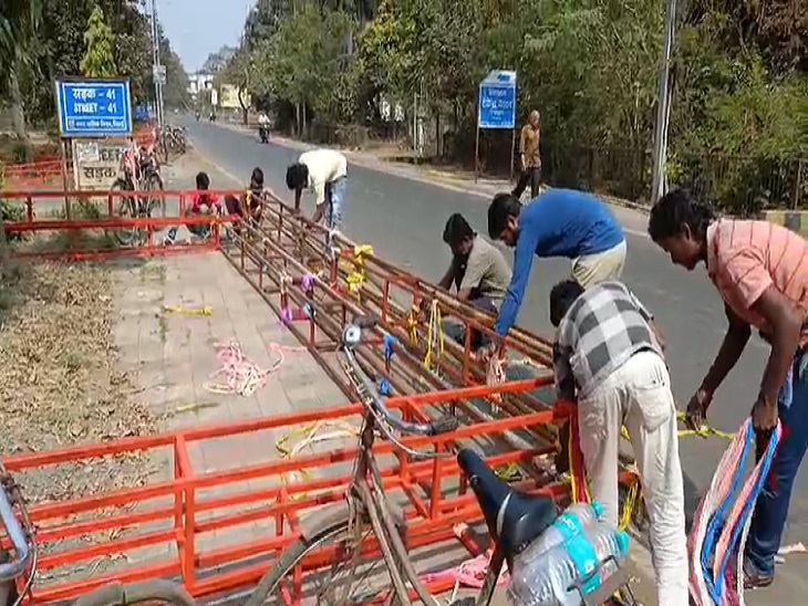 गिरे हुए पंडाल के स्ट्रक्चर को समेटते लोग।