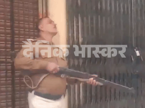 ਹੱਥਾਂ ਵਿਚ ਇਕ ਰਾਈਫਲ ਦੇ ਨਾਲ ਖੜ੍ਹੇ ਪੁਲਿਸ ਕਰਮਚਾਰੀ ਅਤੇ ਇਸ ਇਮਾਰਤ ਨੂੰ ਘੇਰ ਲਿਆ.