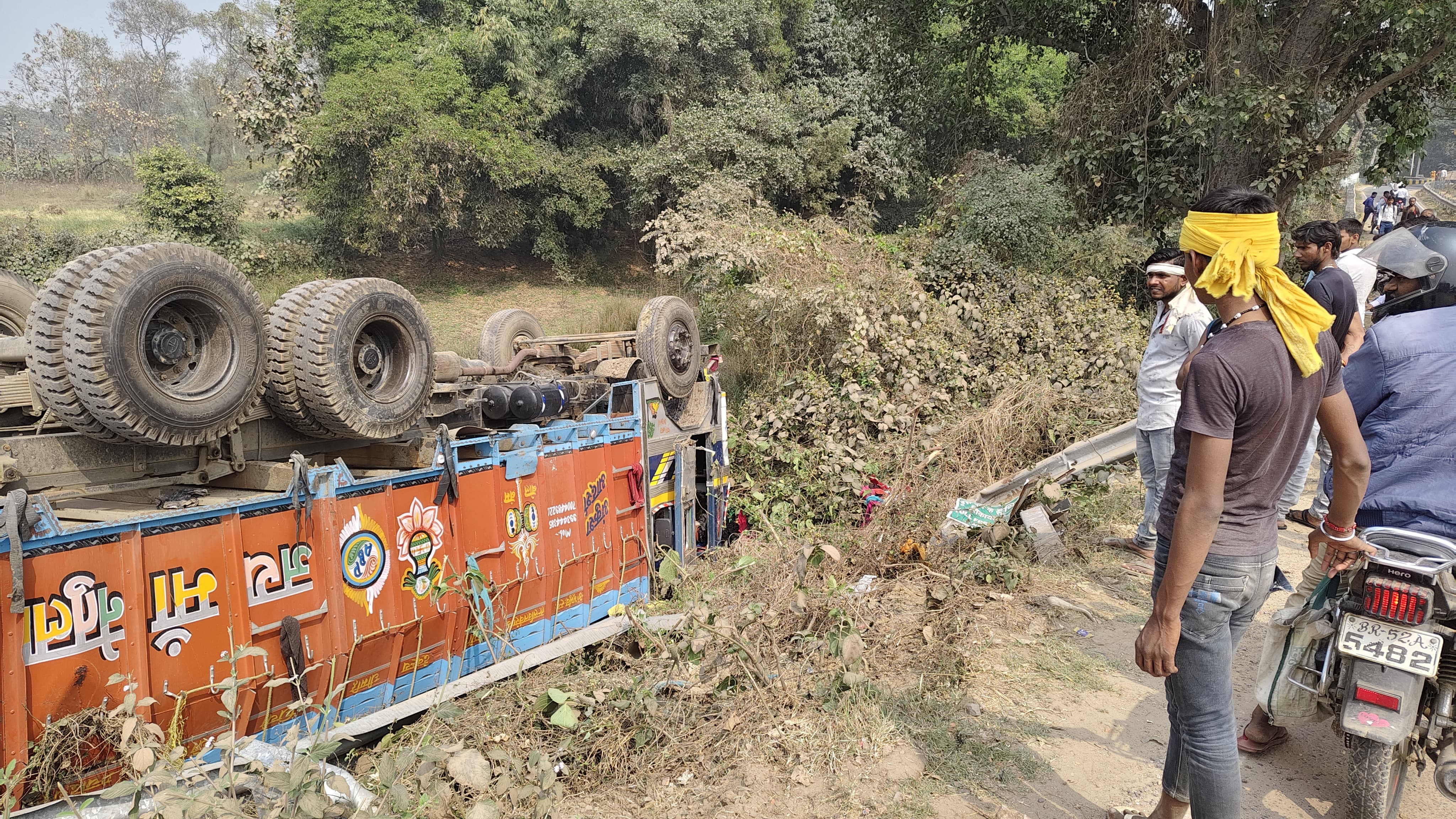 A truck loaded with government rice overturned in a ditch, the driver ...