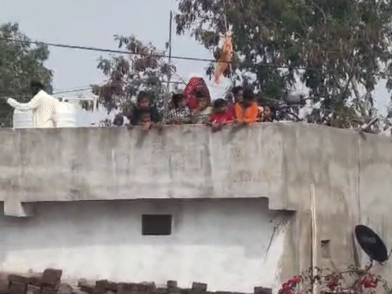 फैक्ट्री के आसपास के लोग कंपनी के अंदर इंसीनरेटर से धुआं उठते देखते हुए।