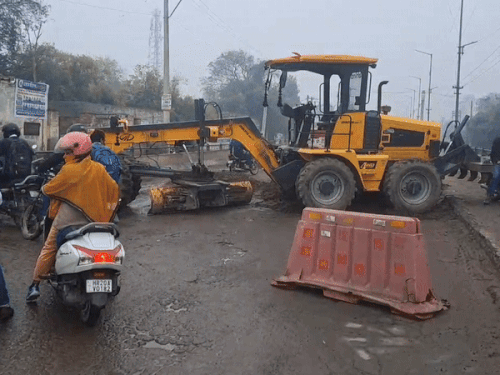 हिसार में जेसीबी को अड़ाकर जिंदल पुल बंद कर दिया गया है। लोग जोखिम उठा निकल रहे हैं। - Dainik Bhaskar