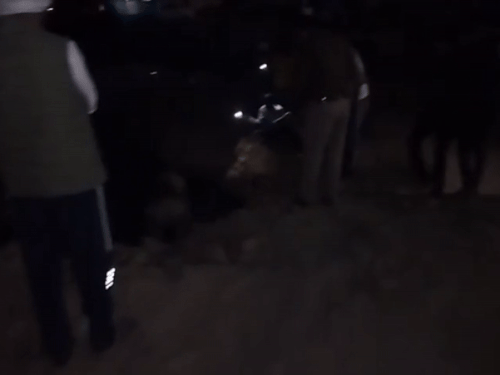 रात के अंधेरे में नाले में गिरे बच्चे के शव को लाठी के सहारे से तलाश करते पुलिसकर्मी