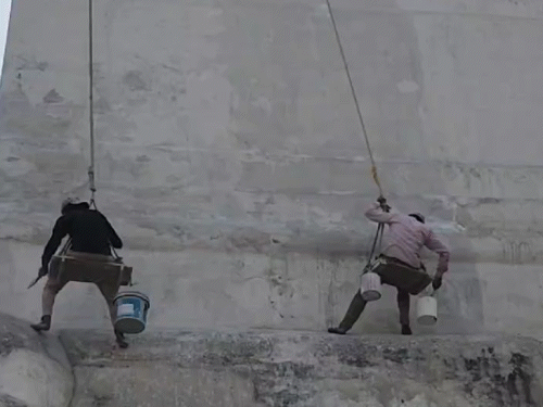 ਮਜ਼ਦੂਰ ਰੱਸੀ ਦੀ ਮਦਦ ਨਾਲ ਲਟਕ ਕੇ ਮਸਜਿਦ ਦੀਆਂ ਕੰਧਾਂ 'ਤੇ ਲਟਕਦੇ ਹਨ.