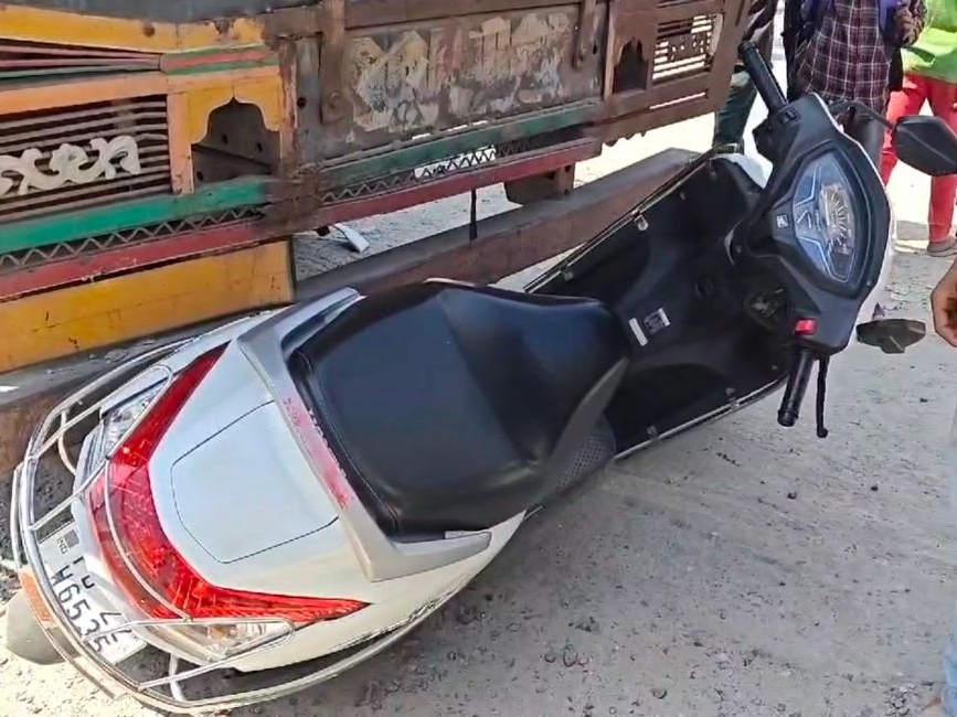 ਸਕੂਟੀ ਟਰੱਕ ਦੇ ਹੇਠਾਂ ਫਸਿਆ.