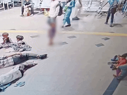 बच्चे रेलवे स्टेशन पर अपने भाई-बहनों के साथ खेल रहा था।