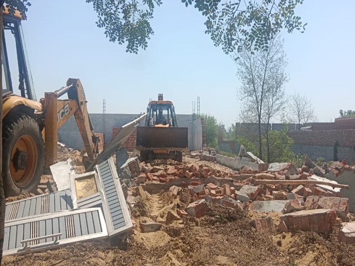 गांव बहु जमालपुर में कच्चे रोड को उखाड़ते हुए बुलडोजर।