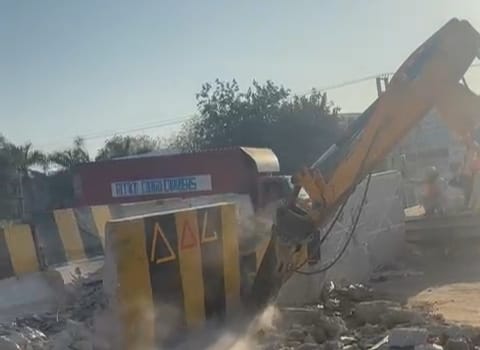 सीमेंट बैरिकेड्स को बुलडोजर से हटाया जा रहे हैं