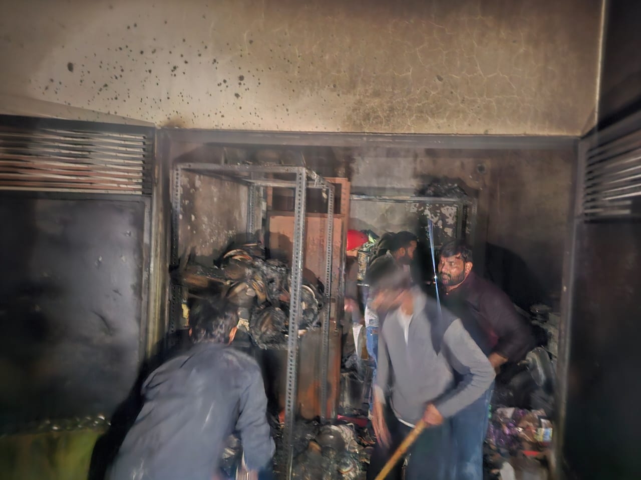 दुकान में लगी आग पर काबू पाते हुए फायर ब्रिगेड कर्मचारी व अन्य। - Dainik Bhaskar