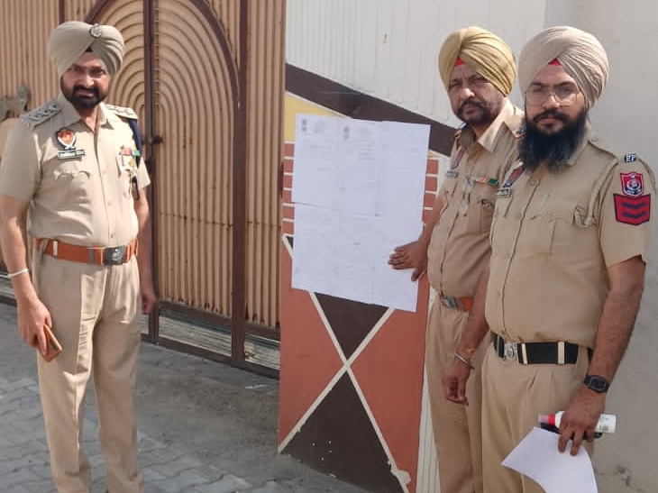 ਪੁਲਿਸ ਅਧਿਕਾਰੀ ਜਾਇਦਾਦ ਜ਼ਬਤ ਕਰਨ ਦਾ ਨੋਟਿਸ ਲਾਗੂ ਕਰ ਰਿਹਾ ਹੈ