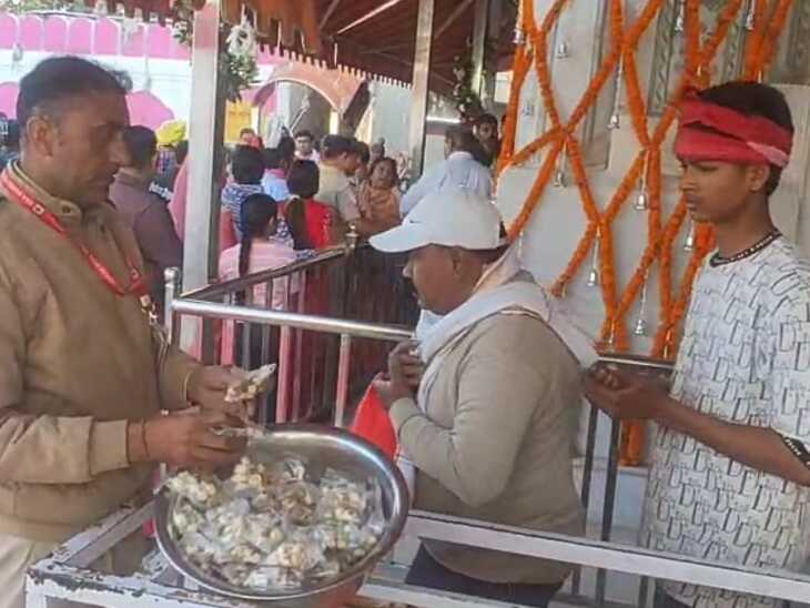 मंदिर से प्रसाद ग्रहण करते श्रद्धालु