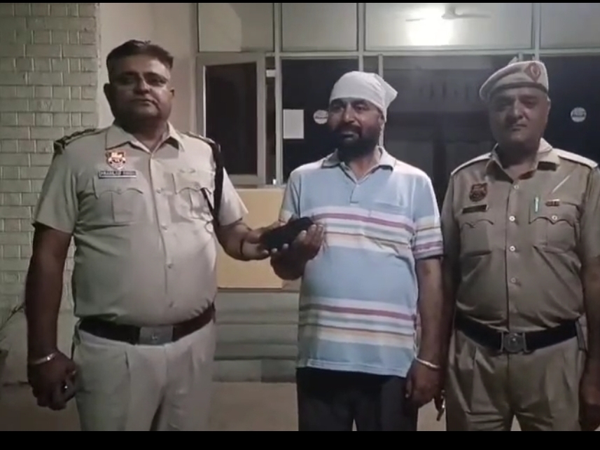 टोहाना में मोबाइल मालिक को सौंपते हुए पुलिस कर्मी। - Dainik Bhaskar