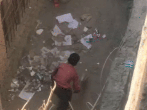 झाडू लगाकर कूड़े को एकत्रित करता हुआ छात्र