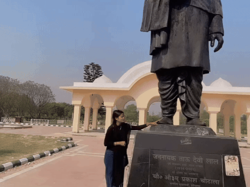 ਤੌ ਦੇਵੀ ਲਾਲ ਦੀ ਮੂਰਤੀ ਦੇ ਬਿਲਕੁਲ ਸਾਮ੍ਹਣੇ ਖੜੇ, ਆਪਣੇ ਪੈਰਾਂ ਦੇ ਪੈਰਾਂ ਨੂੰ ਛੂਹ ਰਹੇ ਹਾਂ ਅਤੇ ਮੁਆਫੀ ਮੰਗਣਾ, ਪਾਣੀਪਤ ਦੀ ਮੁਟਿਆਰ.