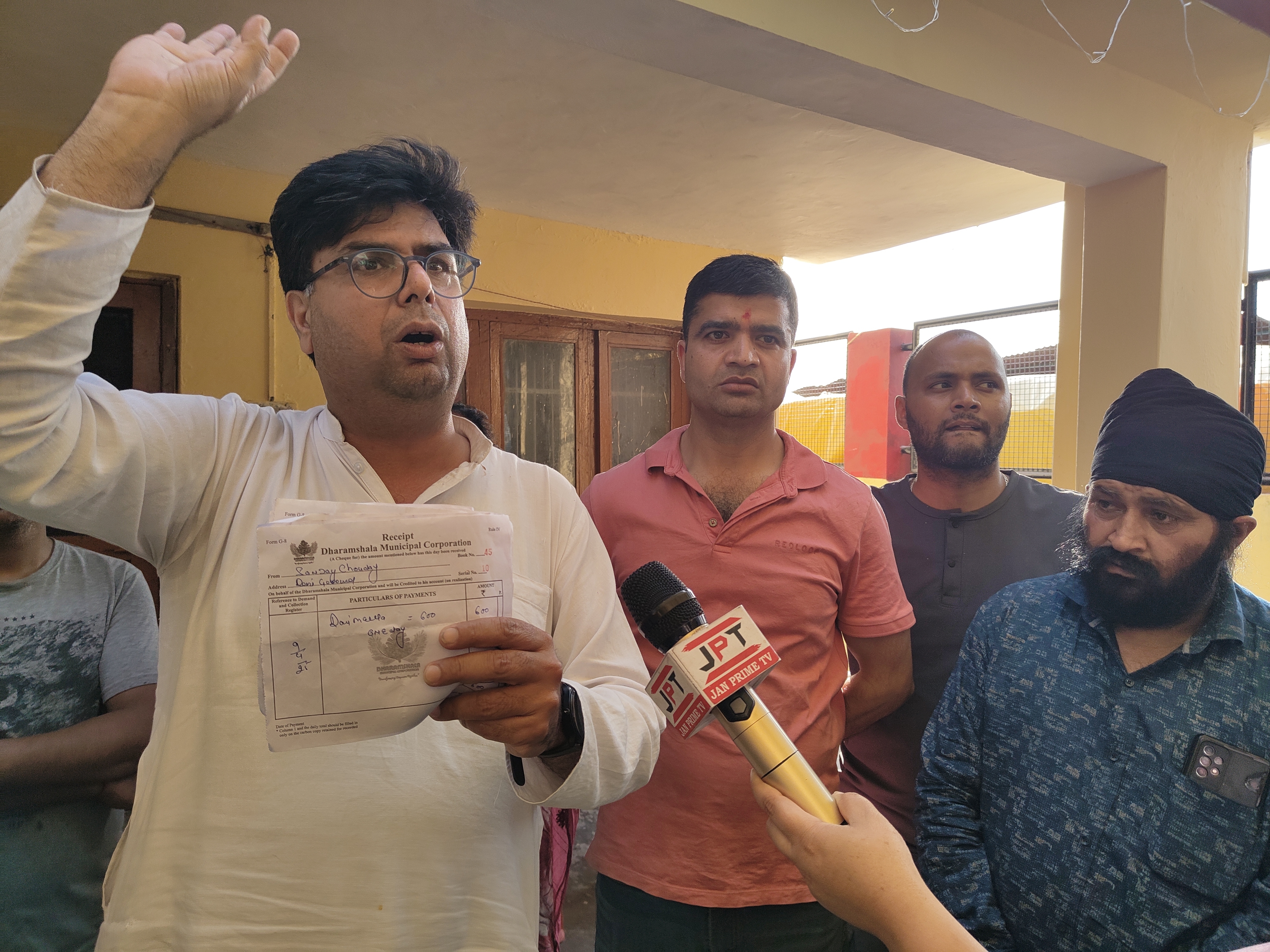 निगम की 2 हजार की रसीद दिखाकर रोष जताते व्यापारी।